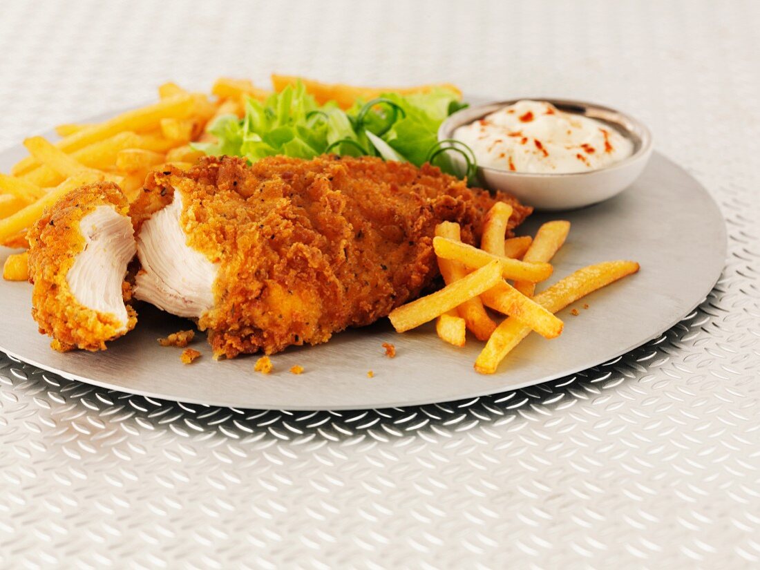 Hot and spicy chicken breast with chips, salad and mayonnaise