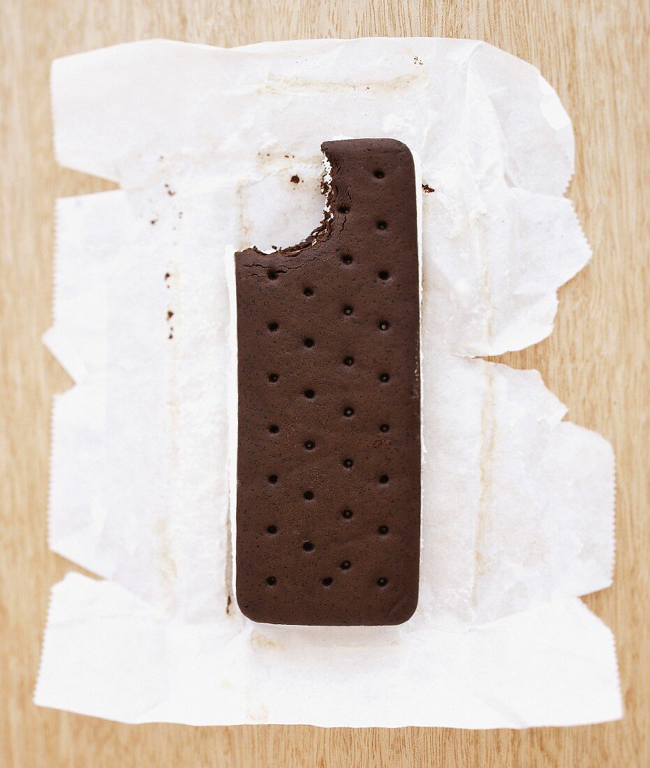 An ice cream sandwich on a piece of paper with a bite taken out
