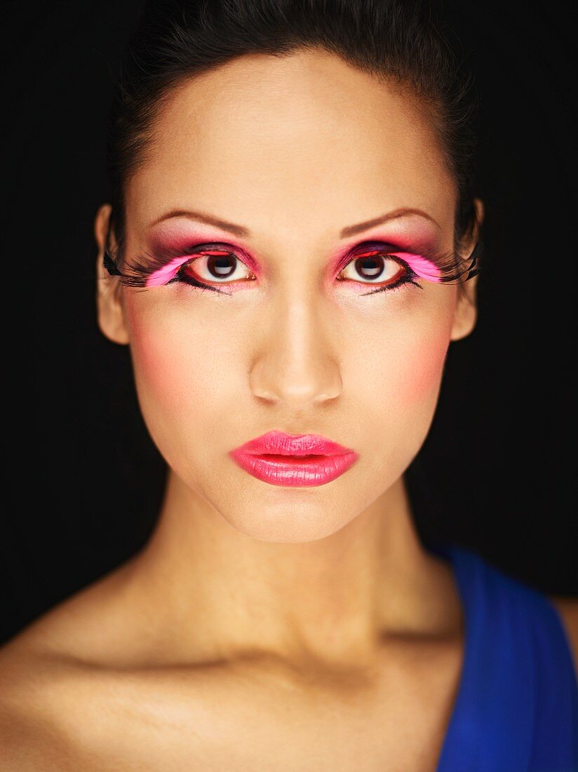 A young woman with pink artificial eyelashes