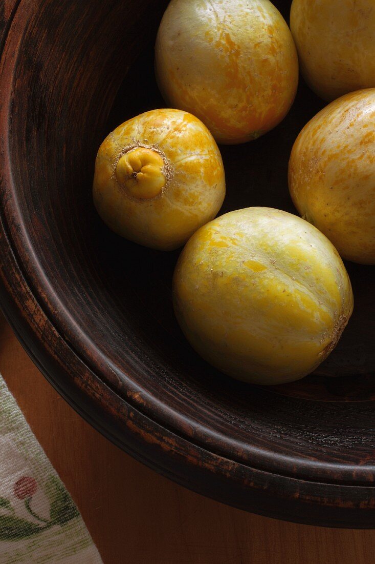 Fresh lemon cucumbers in a wooden bowl