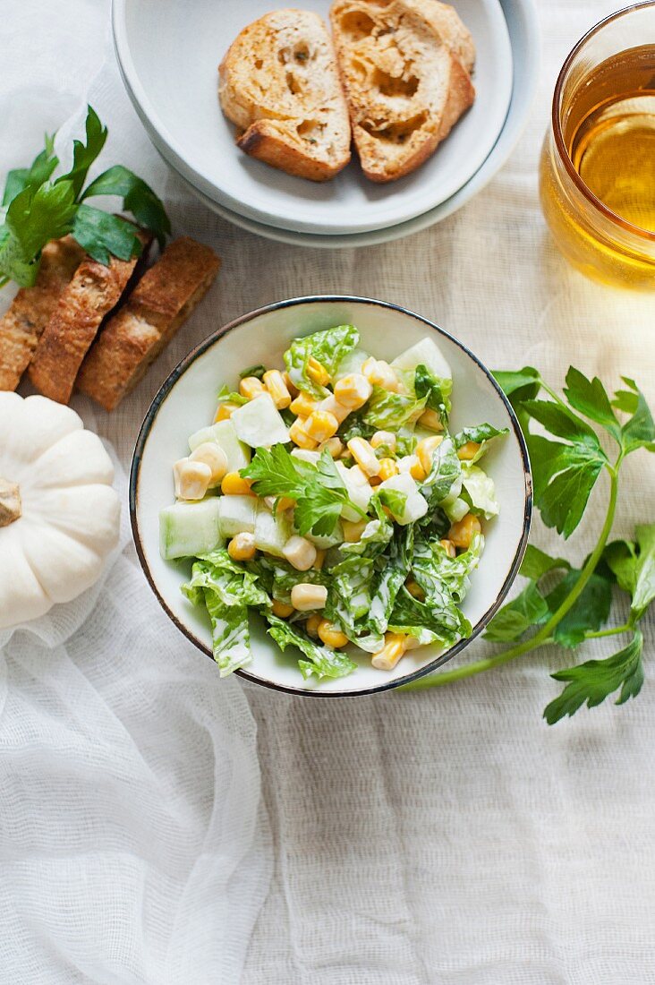 A salad with sweetcorn, parsley and croutons