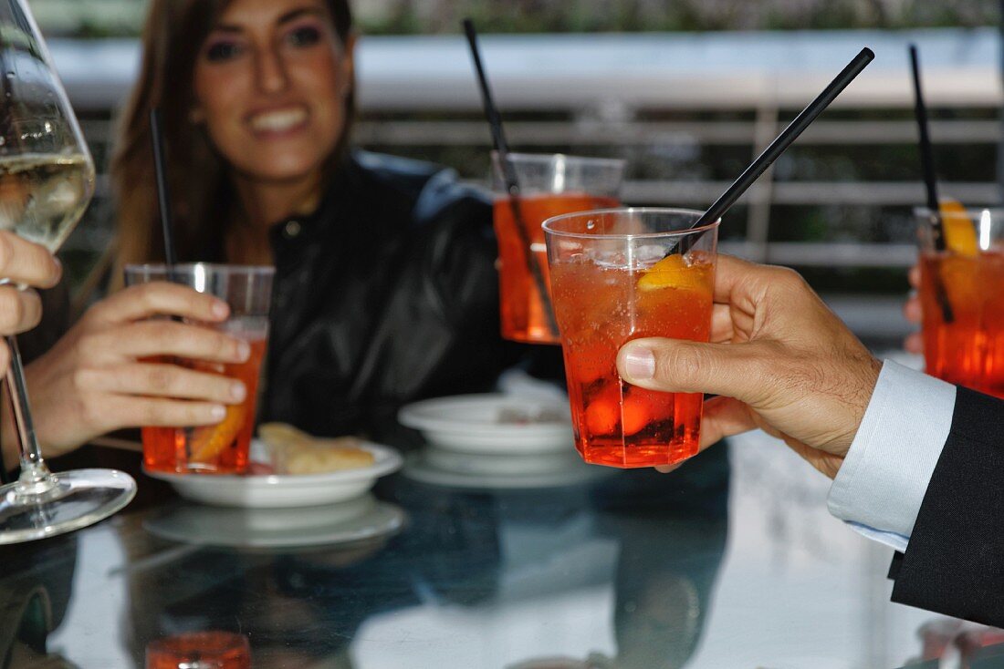Friends raising a toast with cocktails in a restaurant
