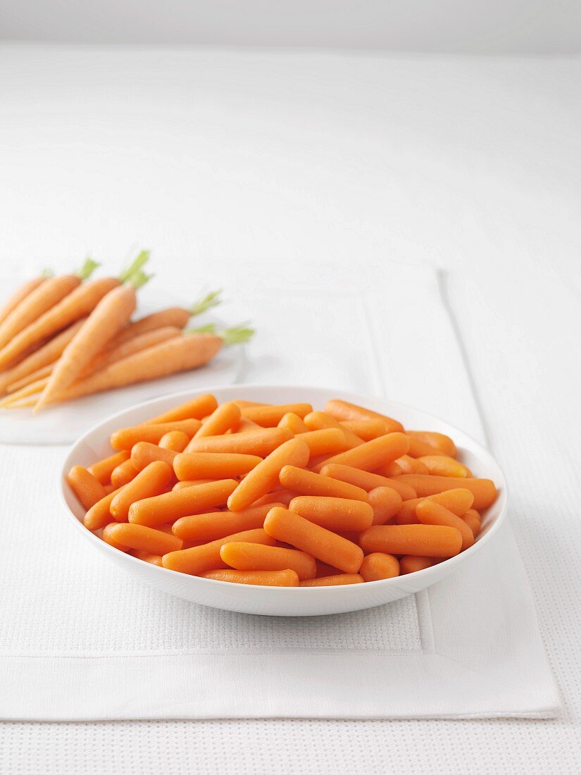 Fresh carrots and a bowl of boiled carrots