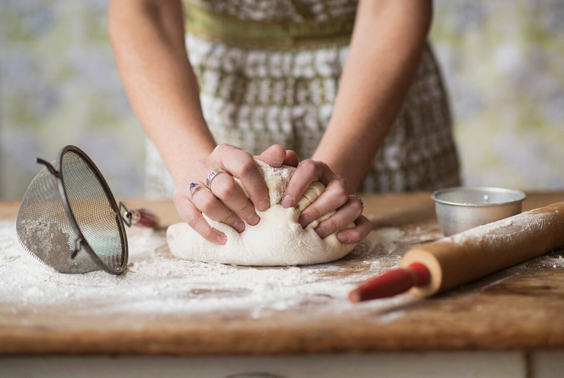 A woman kneading bread dough