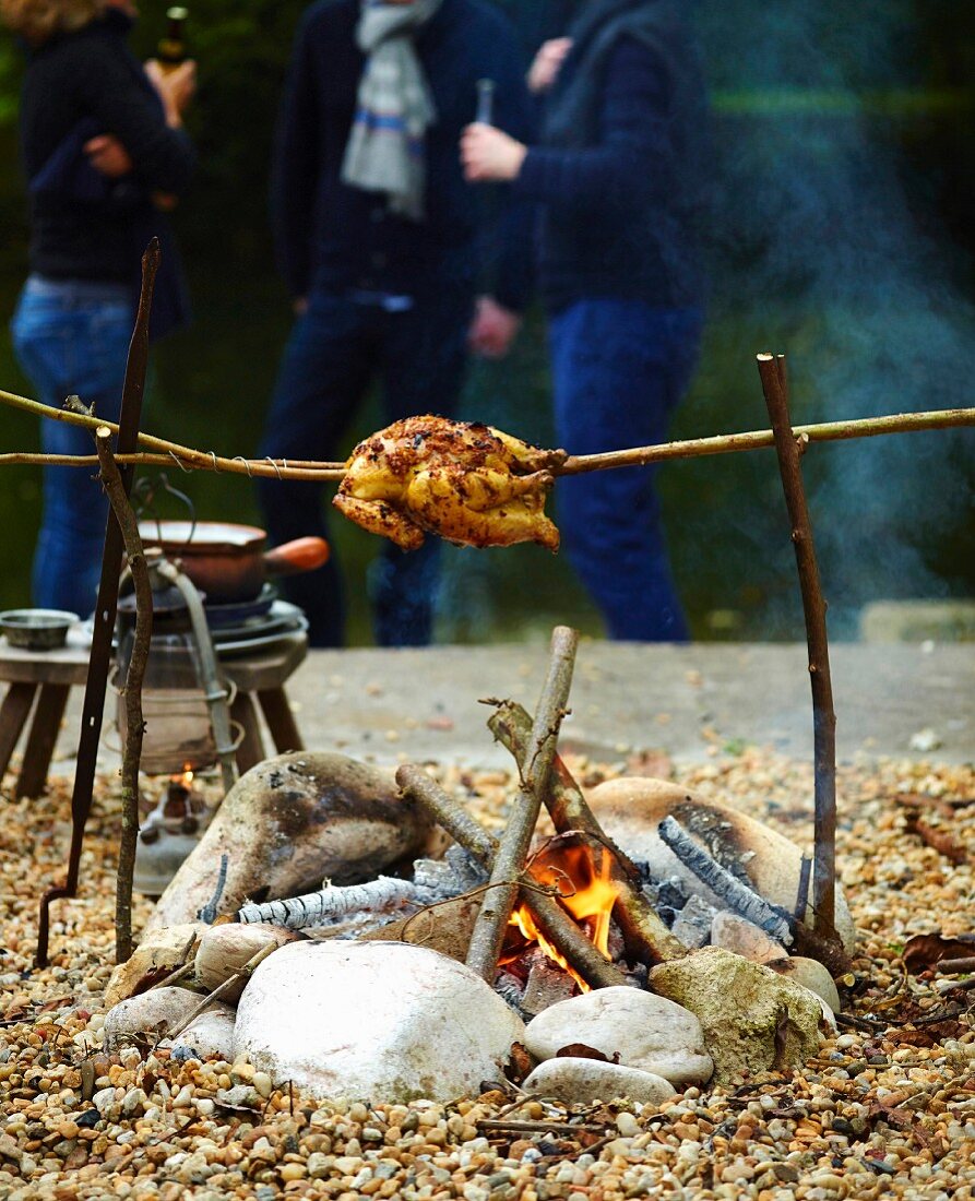 Grilled chicken over a camp fire