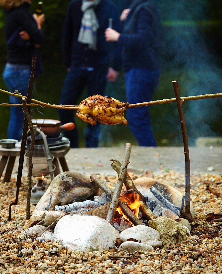 Grillhähnchen über einem Lagerfeuer