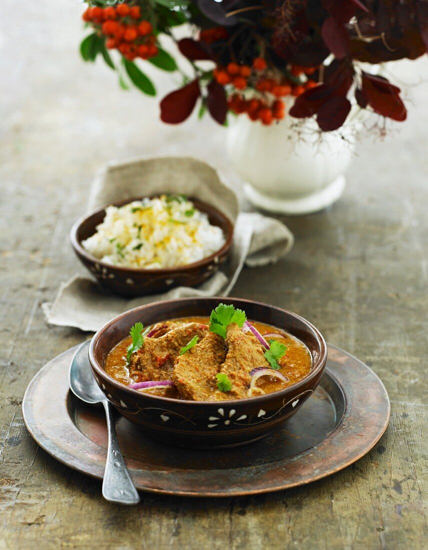 Schweinefleisch in roter Currysauce mit Koriander und Reis