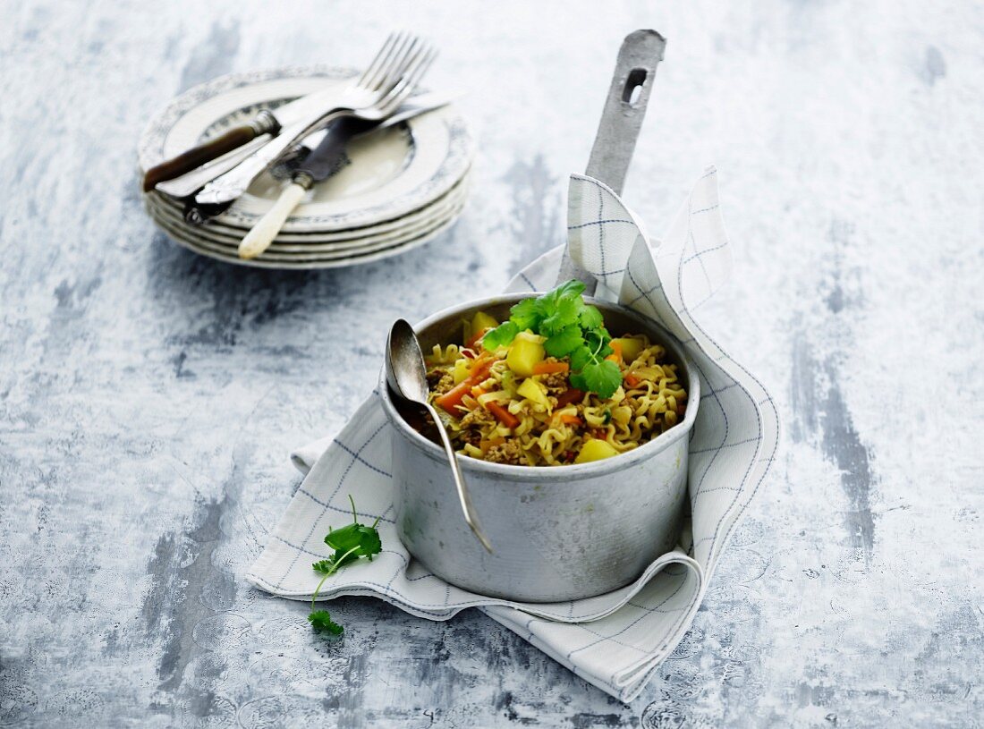 Vegetable stew with pork mince and pasta in a steel pan