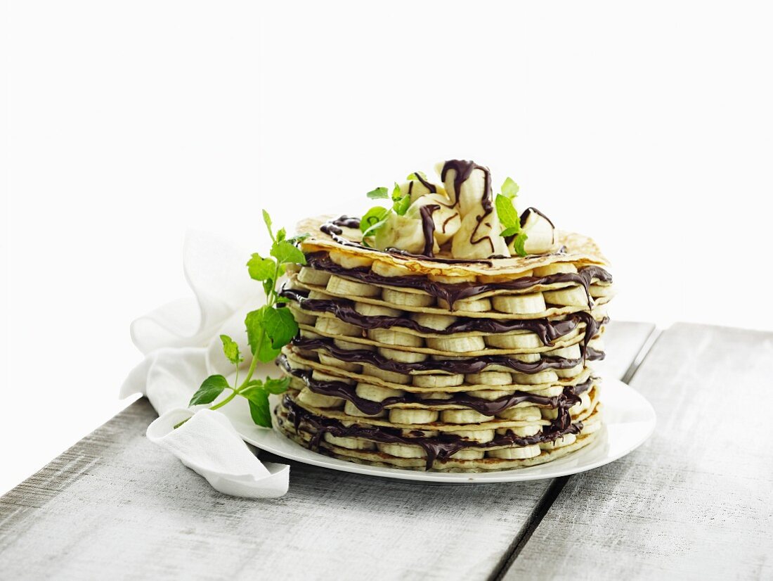 A pancake cake with bananas and nut and nougat cream