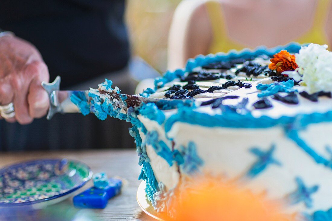 A woman cutting a colourful birthday cake