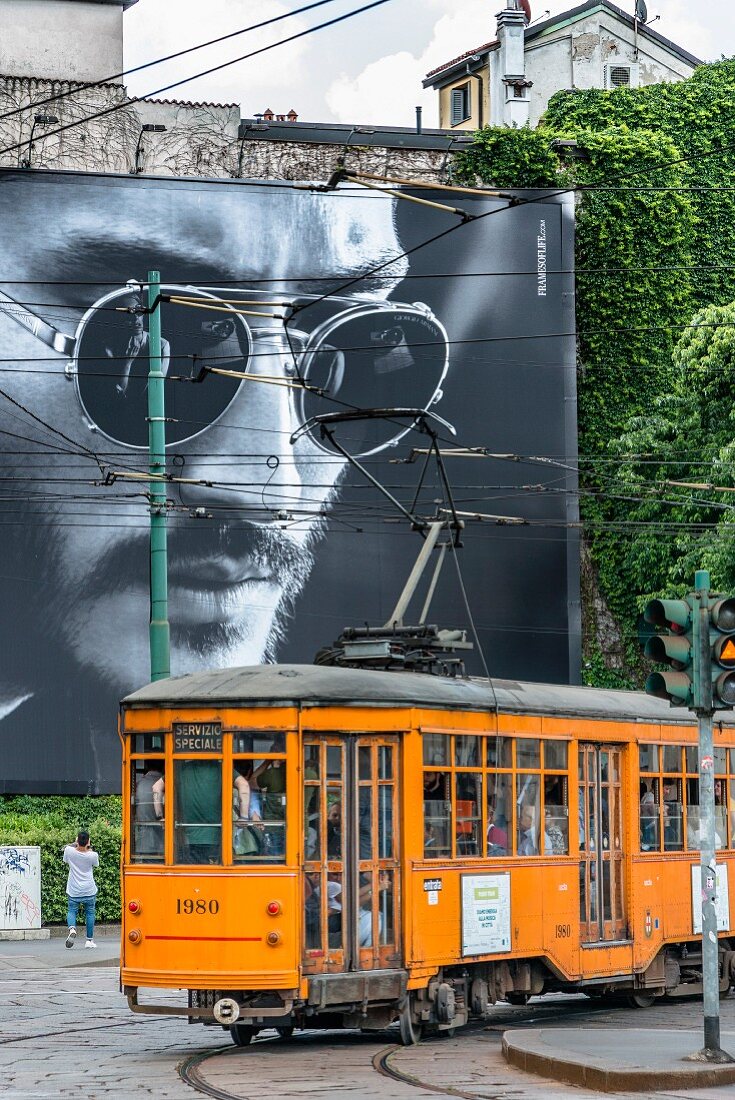 Fashion and nostalgia meet: an old Ventotto tram driving past a Giorgio Armani billboard in Milan