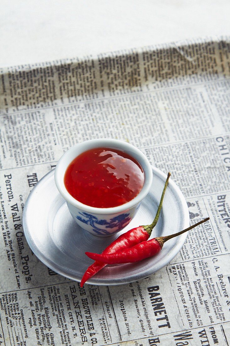 A bowl of chilli chutney on a newspaper