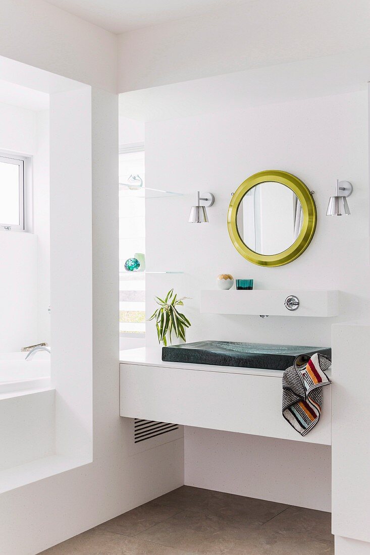 Designerbad mit eingebautem Waschtisch in Nische, an Wand runder, Spiegel mit Goldrahmen