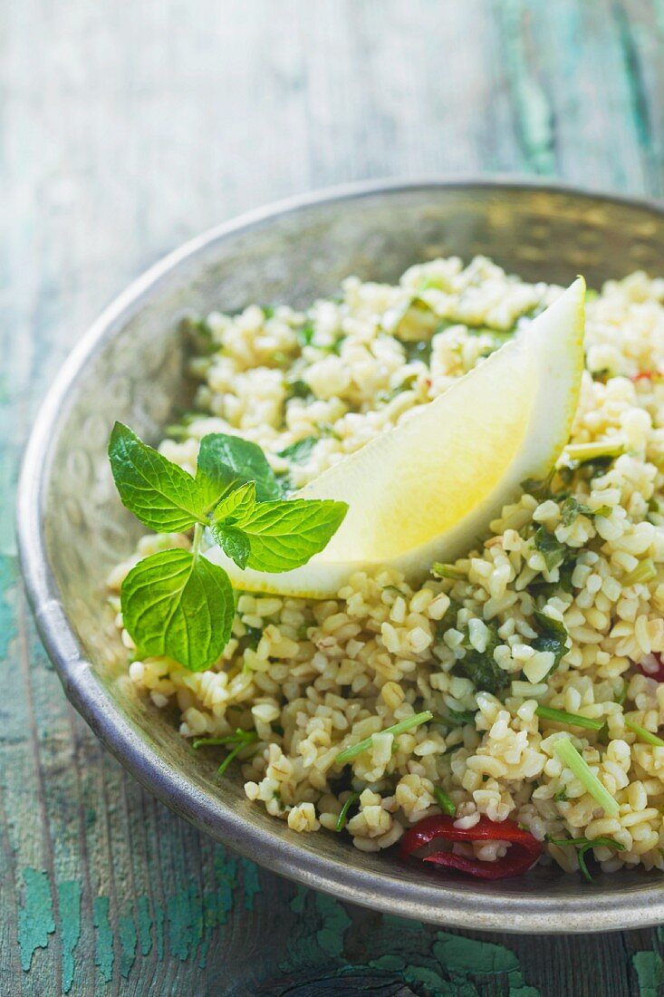 Couscous salad with lemon and mint in a metal bowl