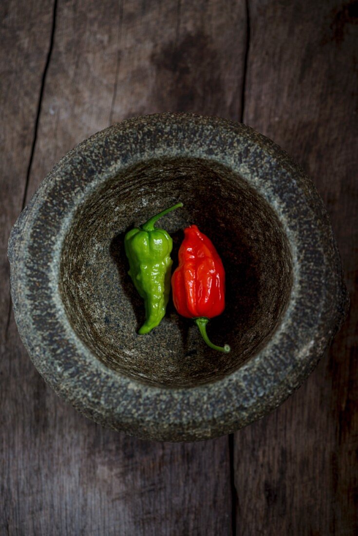 Two fresh chillis in a mortar