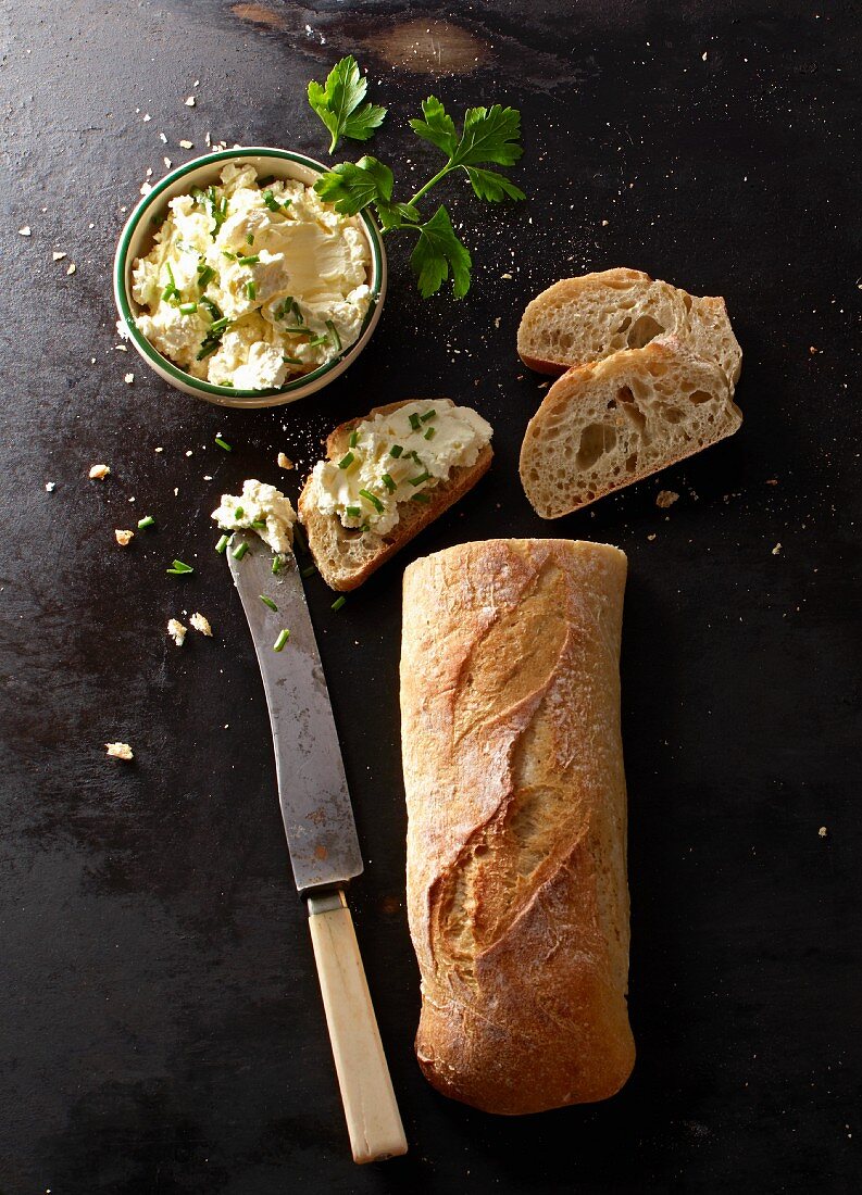 Baguette with a knife and cream cheese