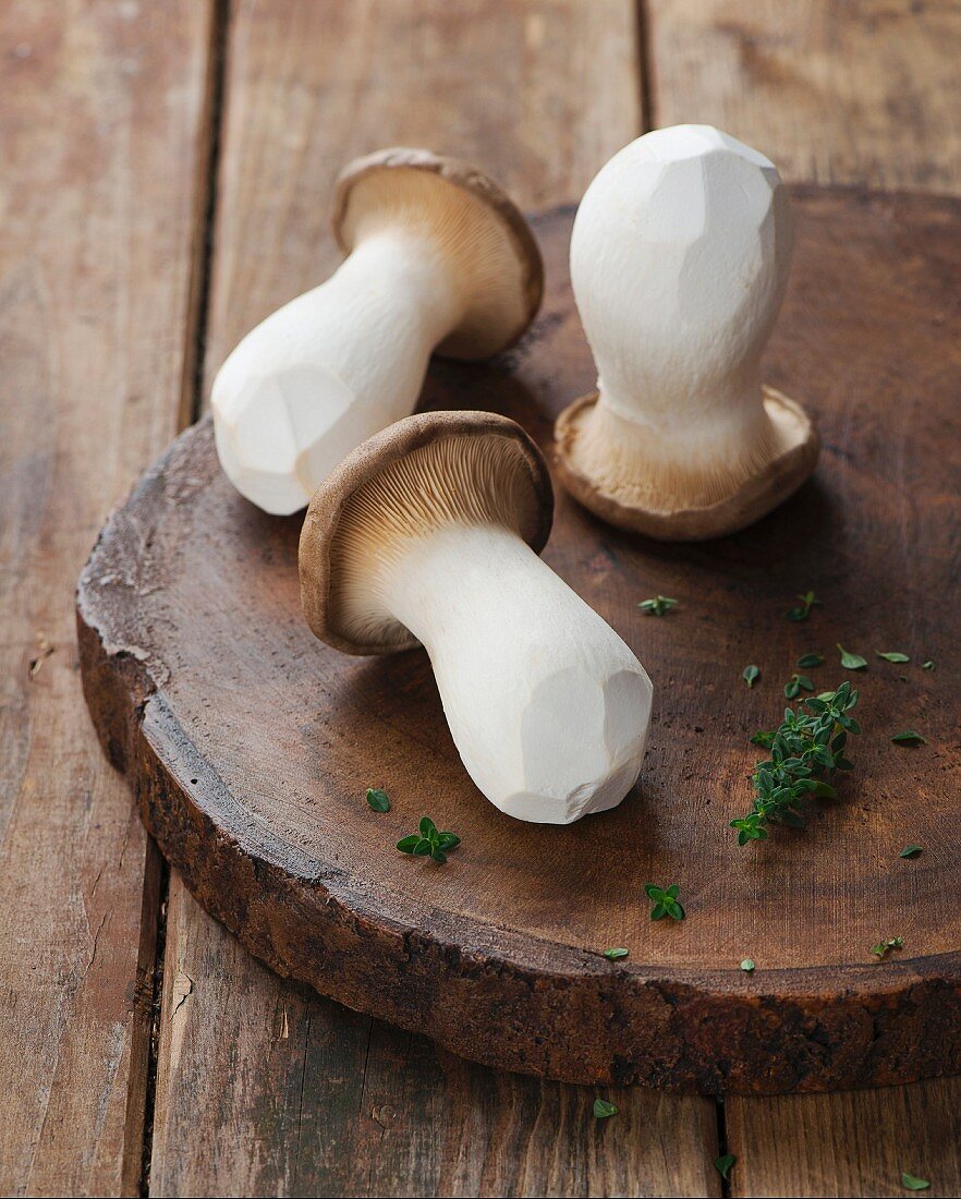 Fresh king trumpet mushrooms on a wooden board