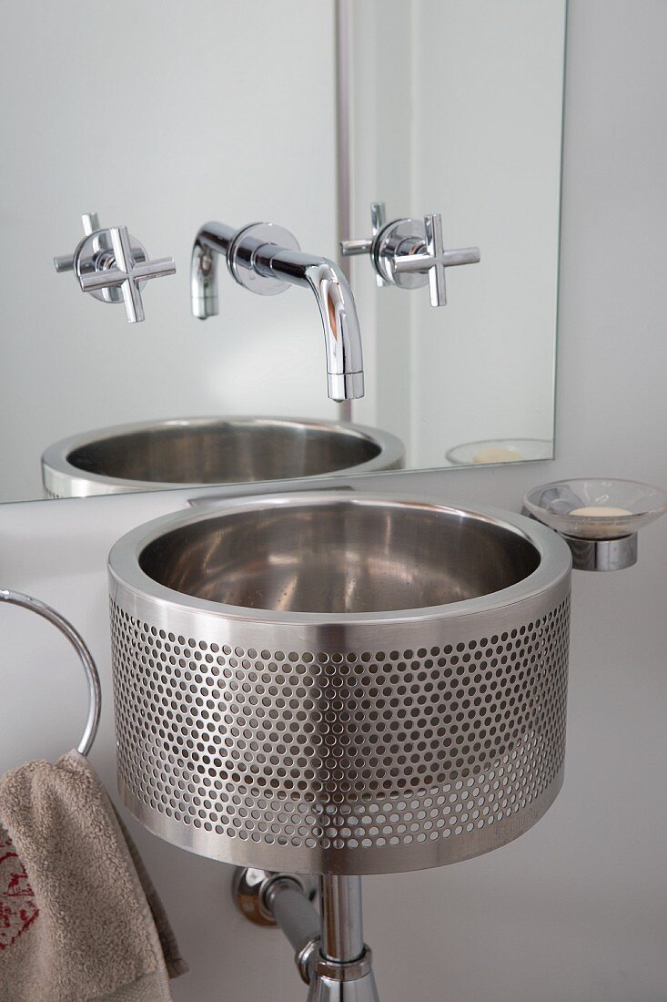 Minimalist, stainless steel washstand below wall-mounted tap fitted on mirror