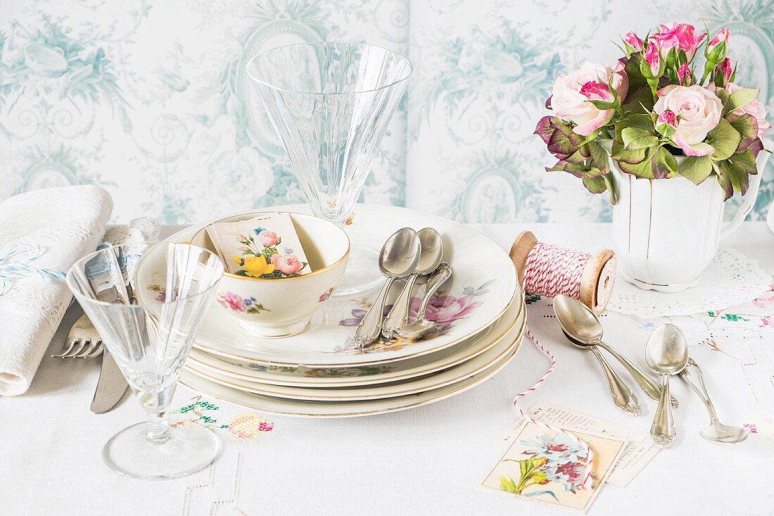 Crockery, cutlery, glasses, table cards and a bunch of flowers for an Easter table