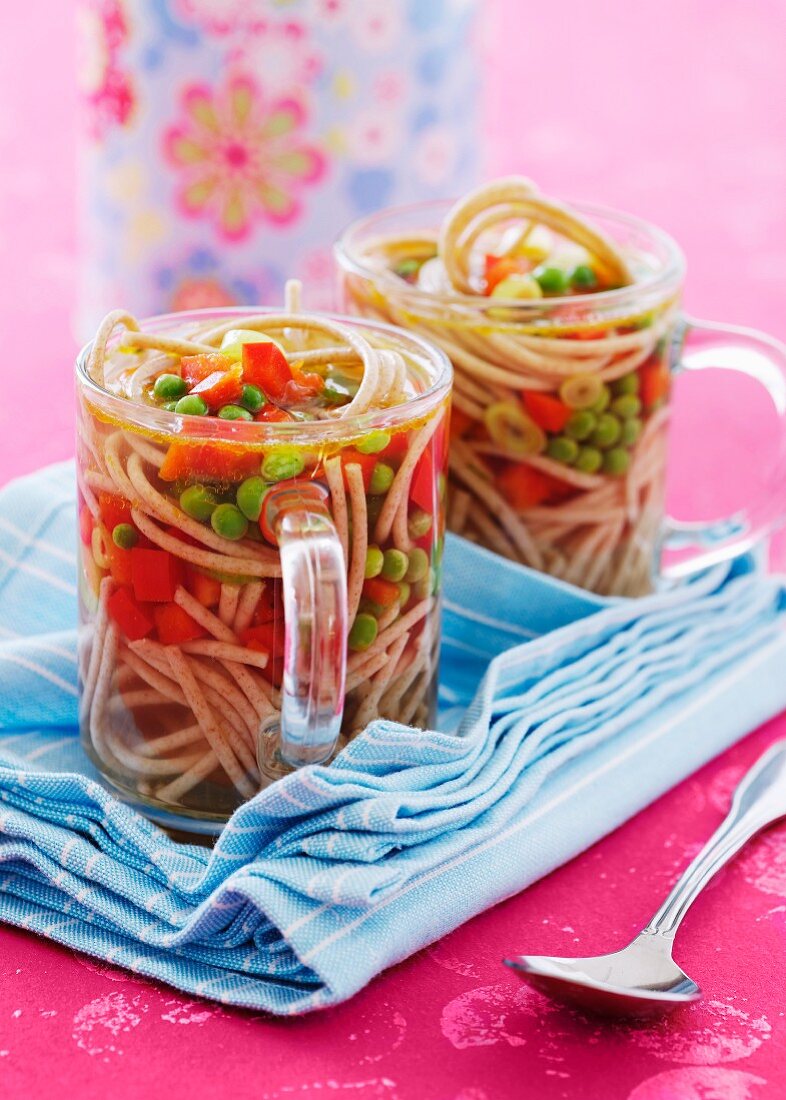 Noodle soup with vegetables in two glasses