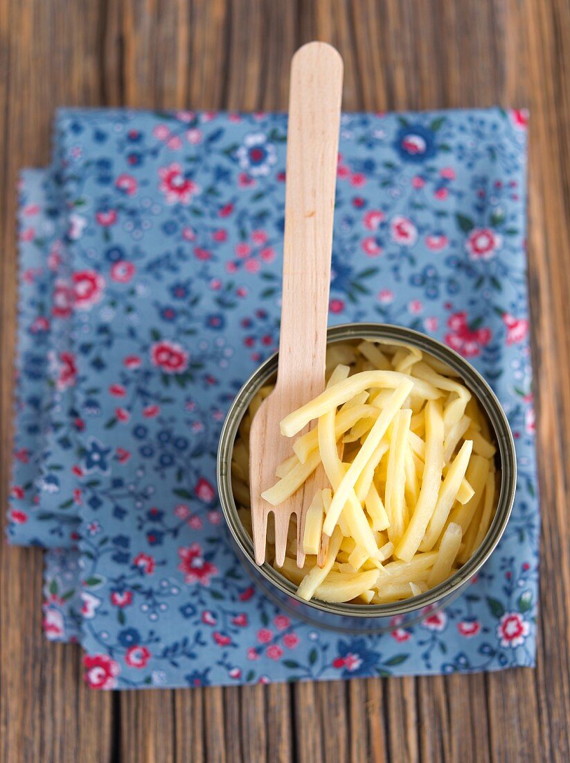 Bamboo shoots in a tin with a wooden fork