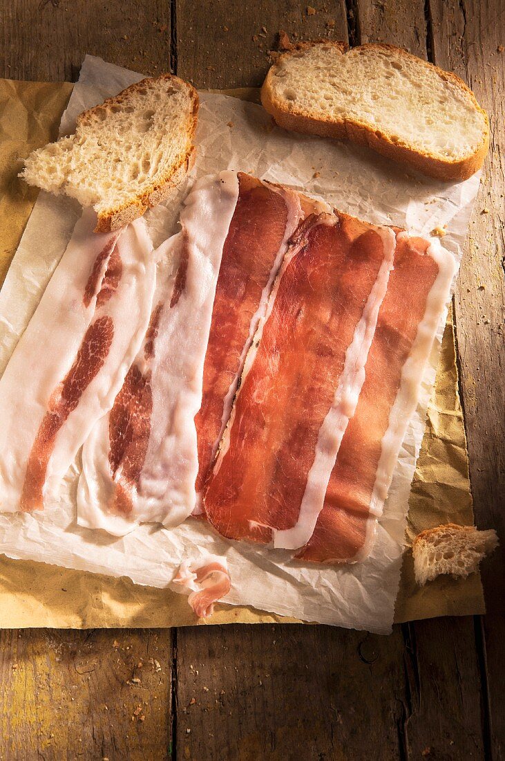 Speckscheiben und Brot auf Papier