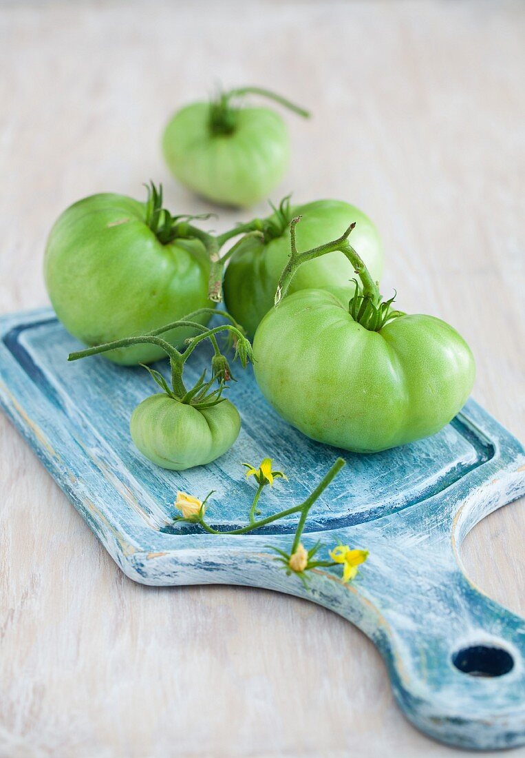 Green tomatoes on a blue chopping board