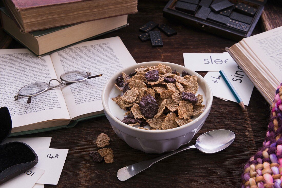 Cornflakes with milk surrounded by books