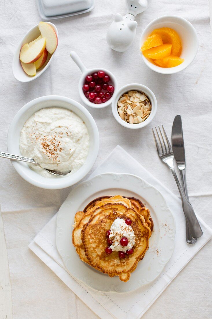 Pancakes with coconut and cinnamon quark, redcurrants, fruit and flaked almonds