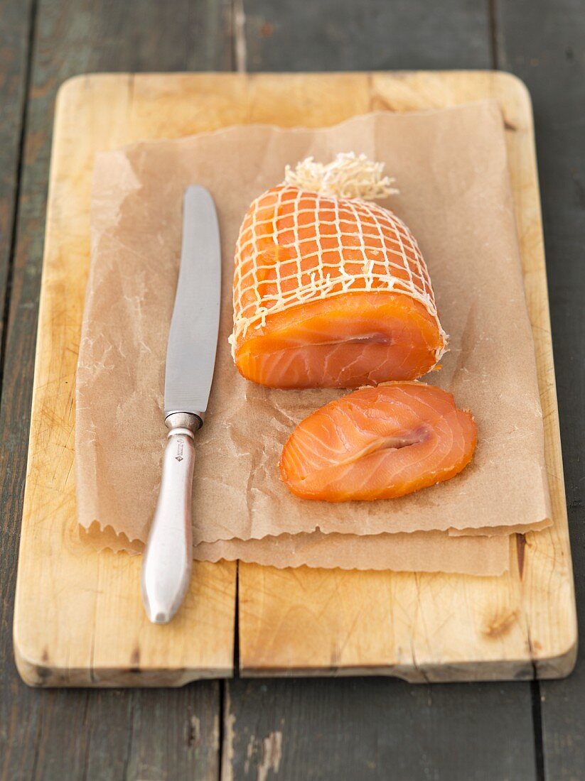 Smoked salmon in a net on a chopping board