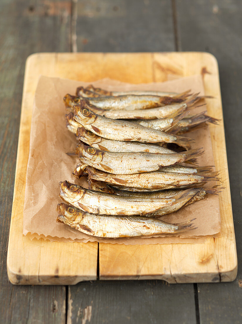 Smoked sprats on a chopping board