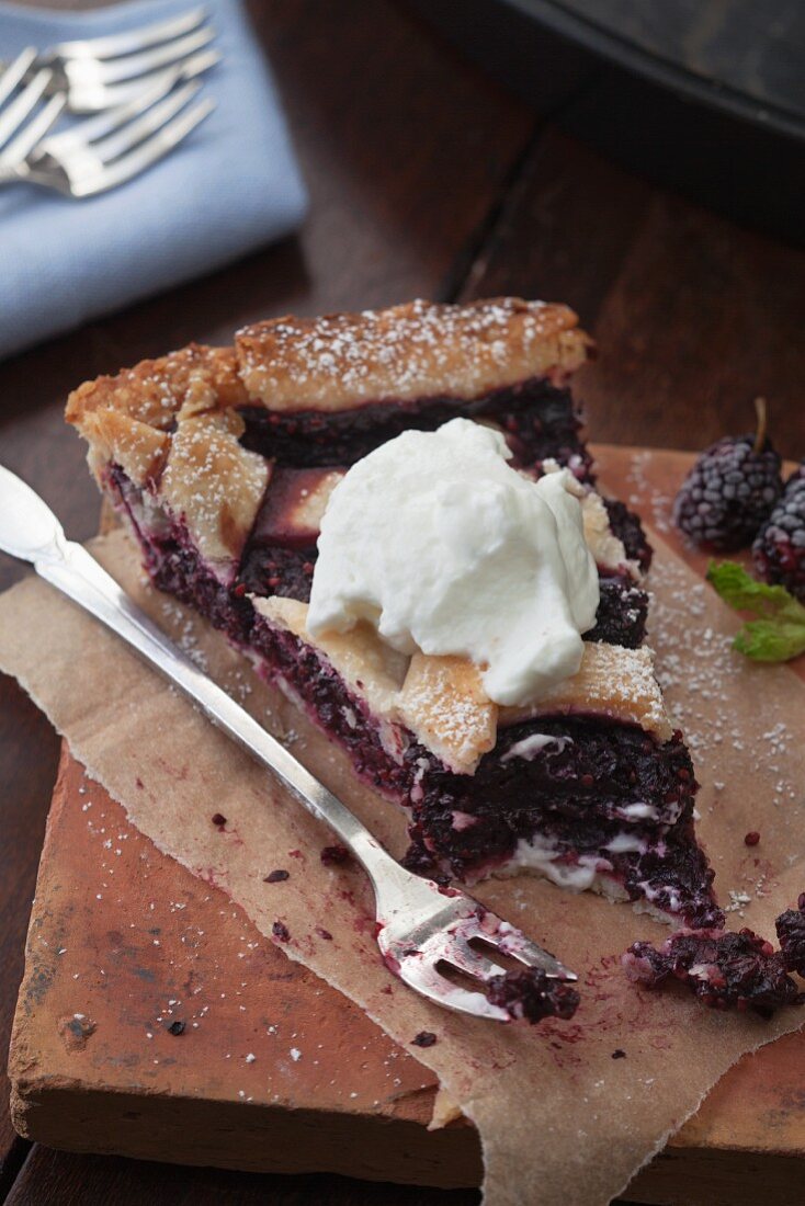 Ein Stück Maulbeerpie mit Sahne, angebissen