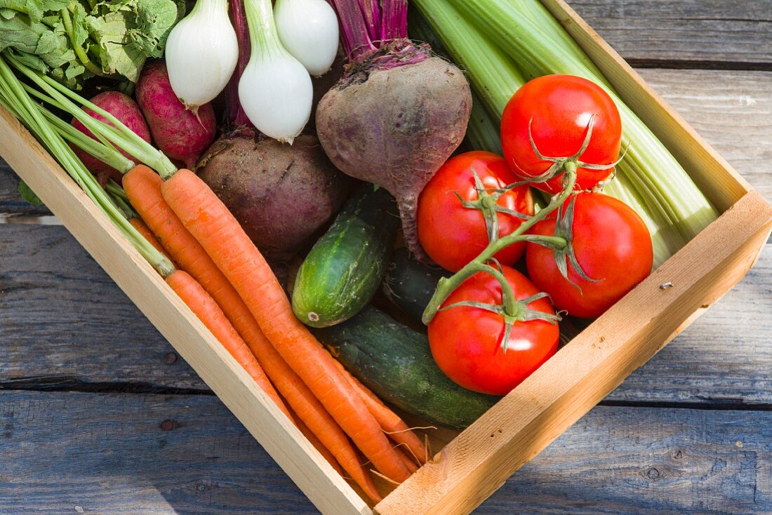 A wooden crate of fresh vegetables