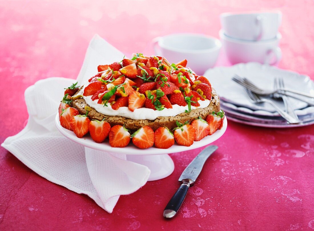 A cake with whipped cream and strawberries