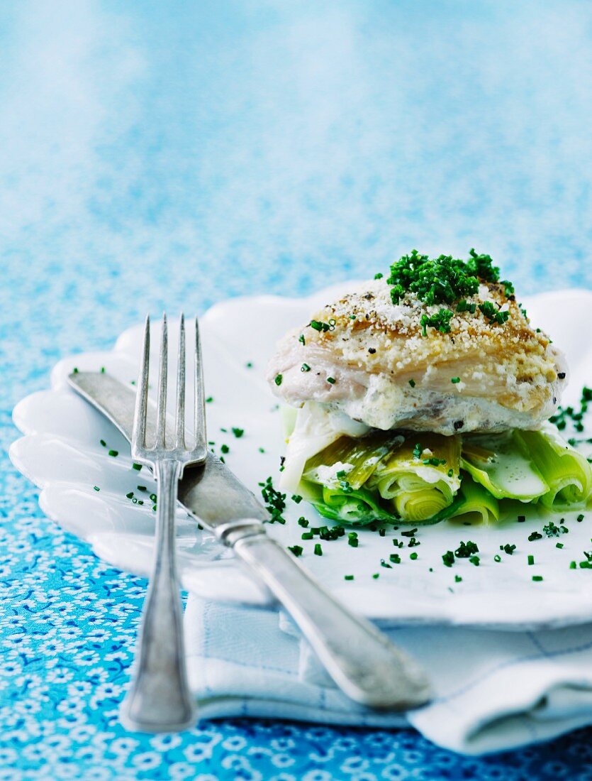 Gebackener Kabeljau auf Lauch mit geriebenem Parmesan, Schnittlauch und Weißwein-Sahne-Sauce