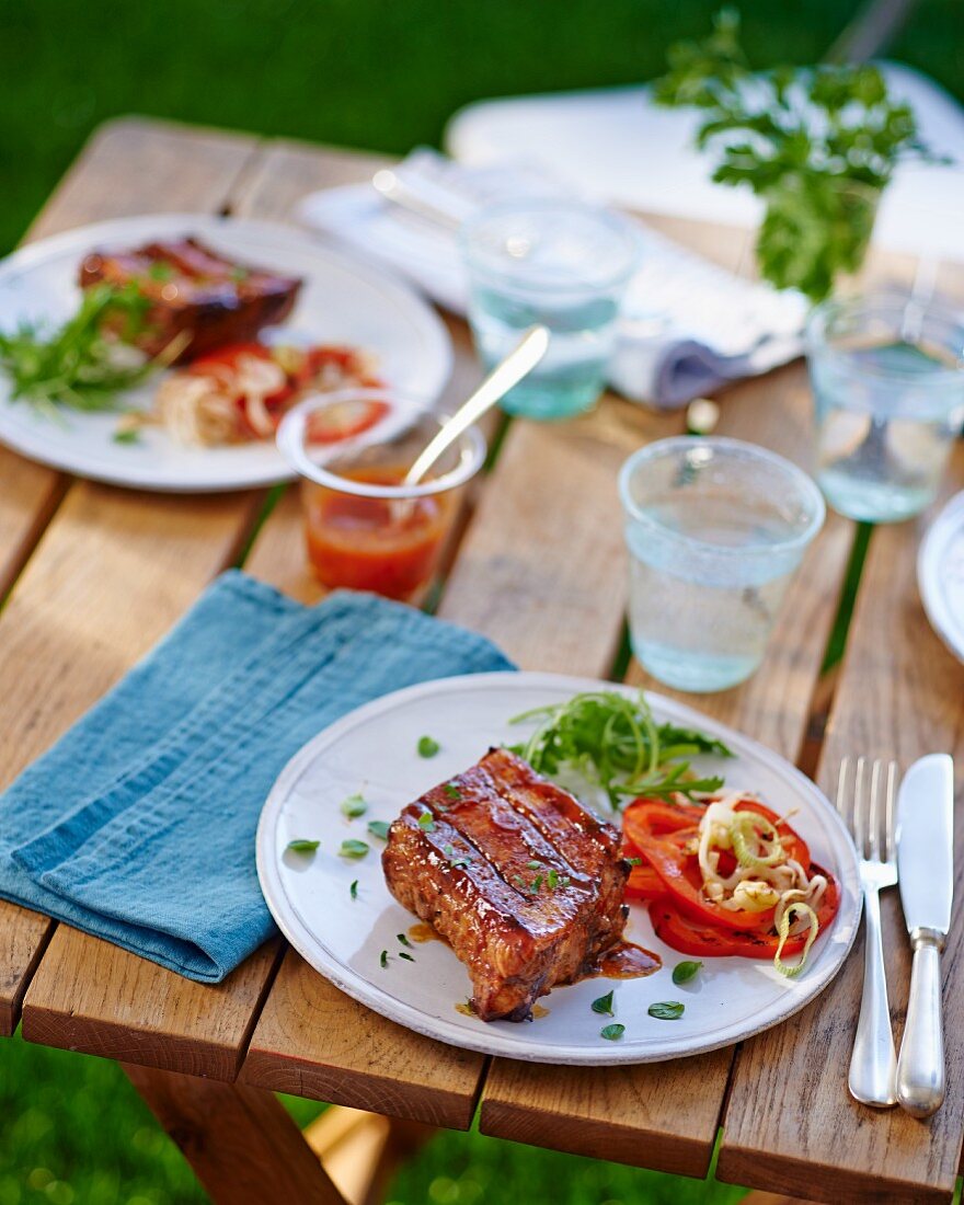 Grilled pork ribs with a pepper salad and ketchup