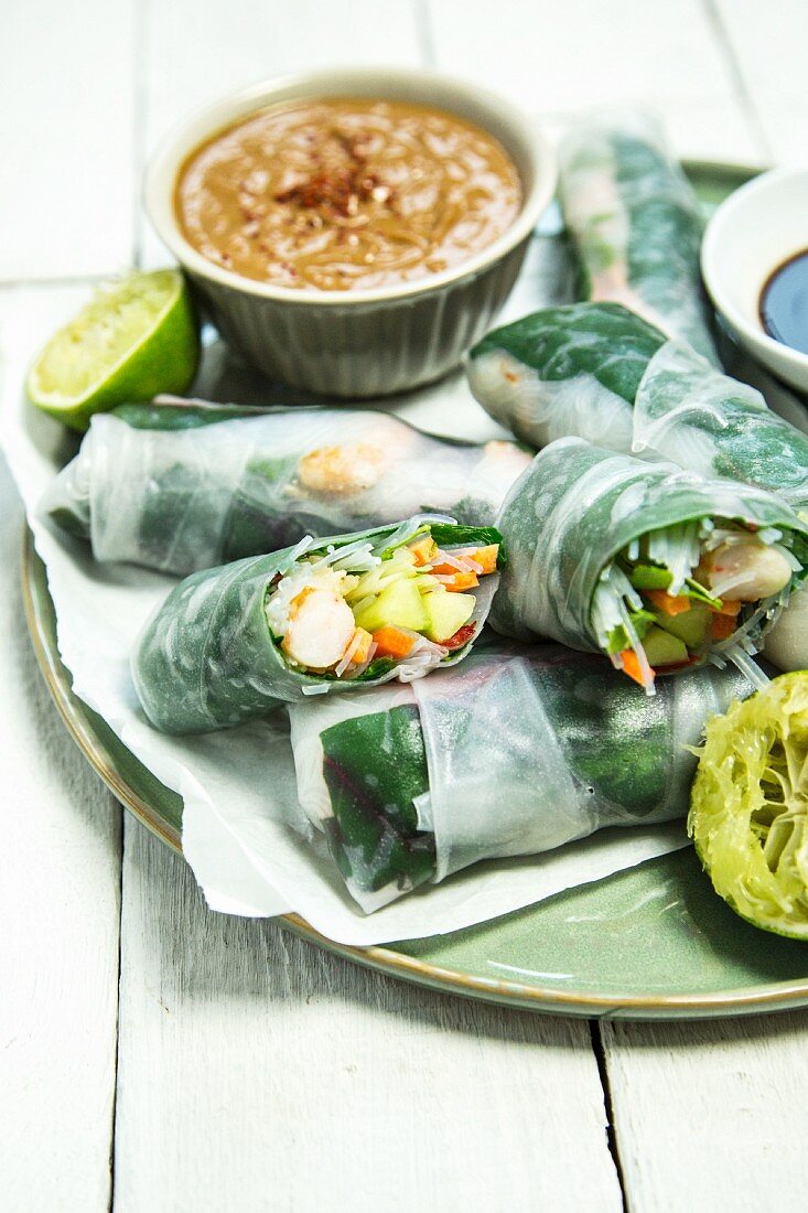 Rice paper rolls filled with vegetables served with lime and a peanut dip