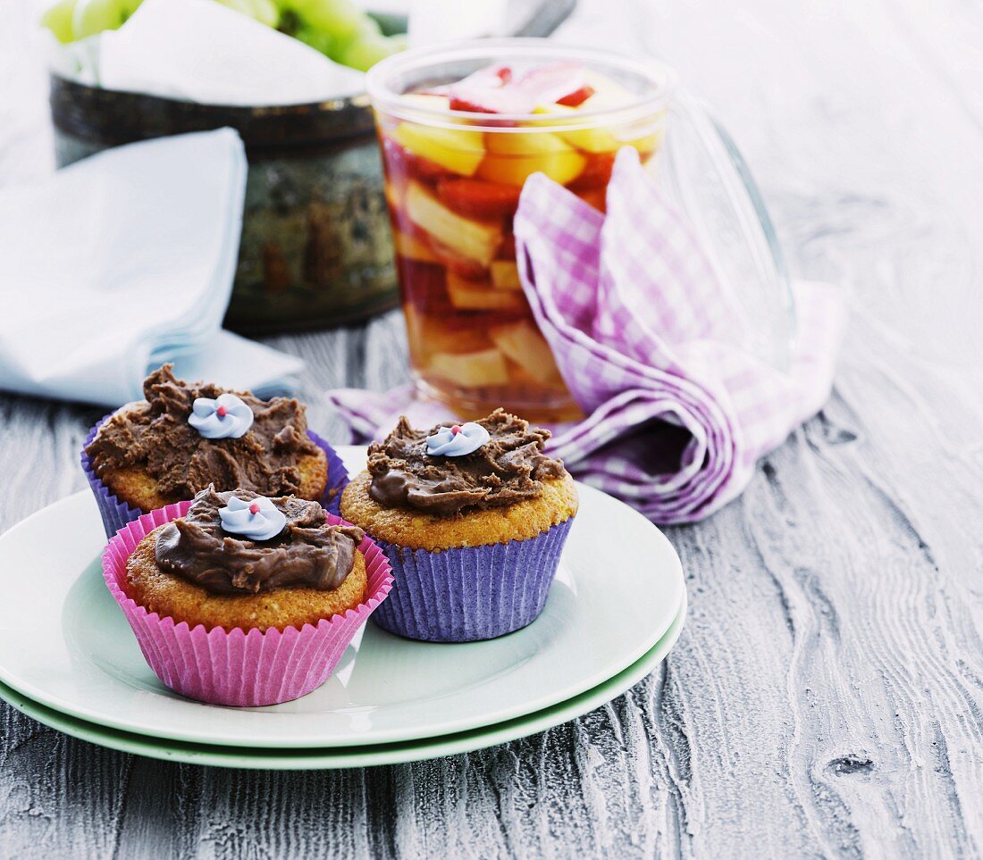 Three muffins with chocolate cream and sugar flowers