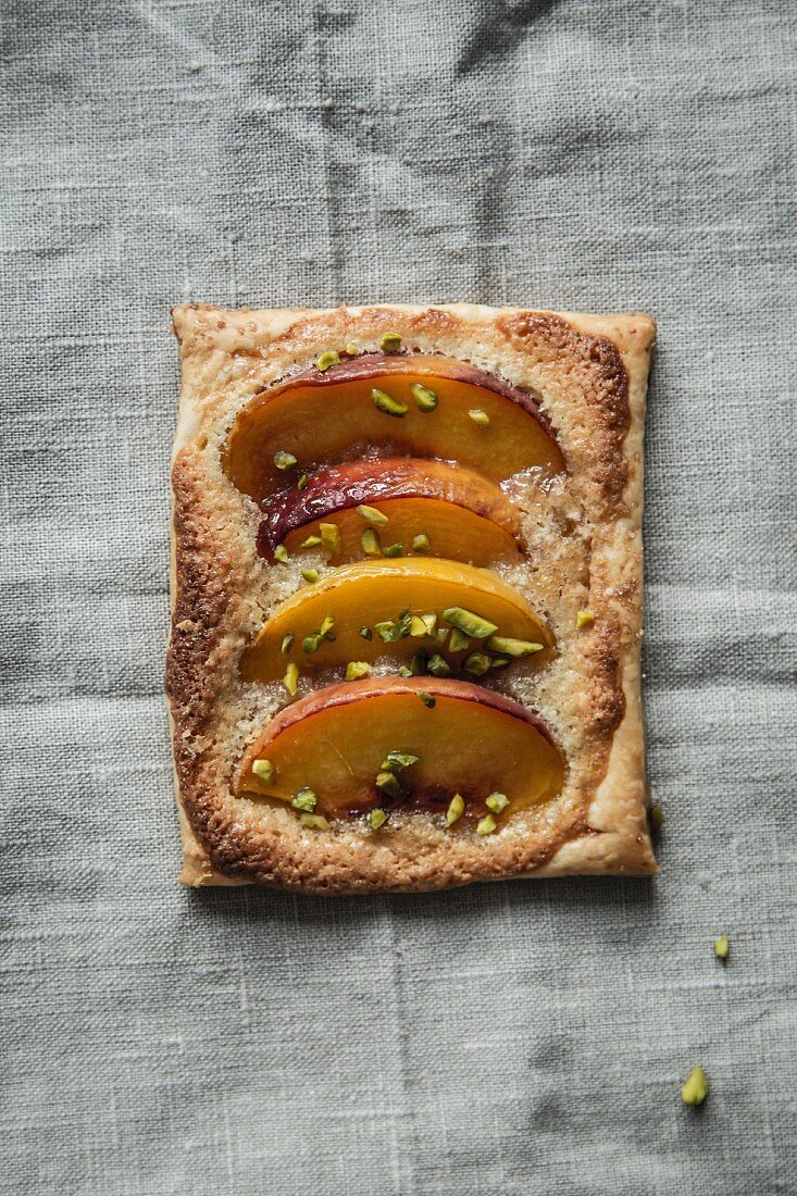 A peach tartlet with chopped pistachios