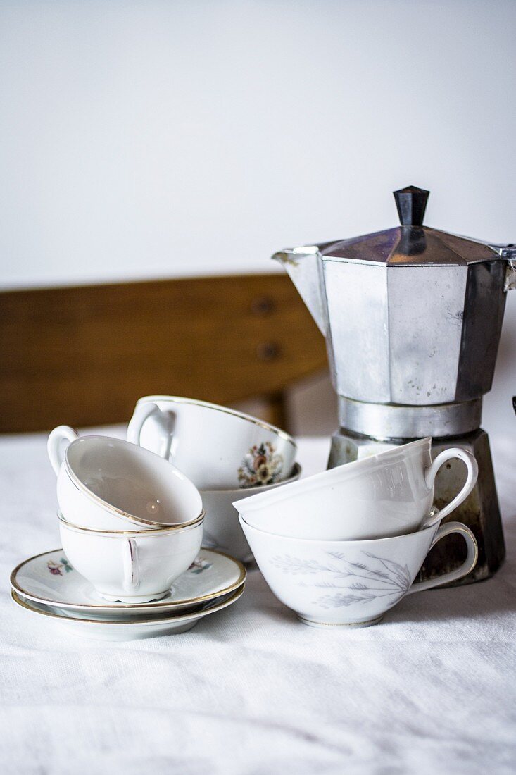 Old-fashioned coffee cups and an espresso machine