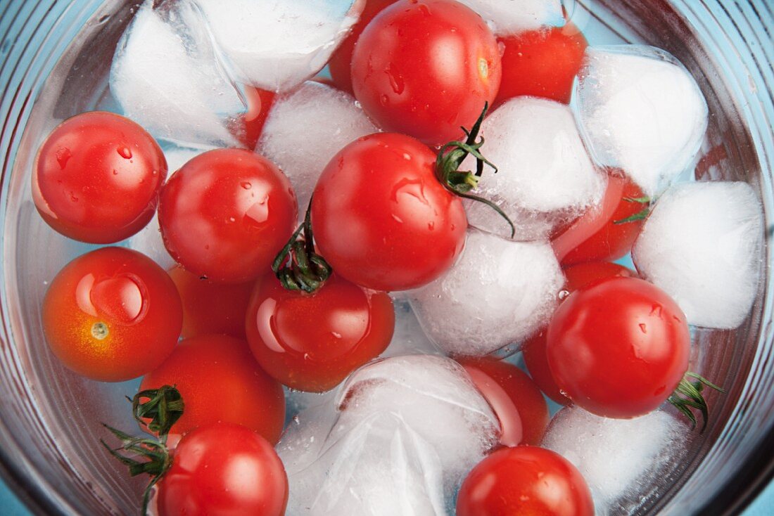 Cherry tomatoes in a bowl of ice water (seen from above)