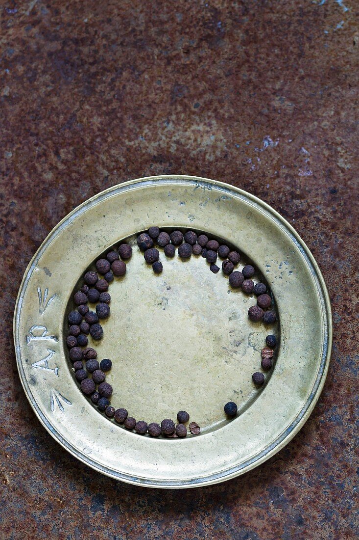 Black peppercorns on a metal plate