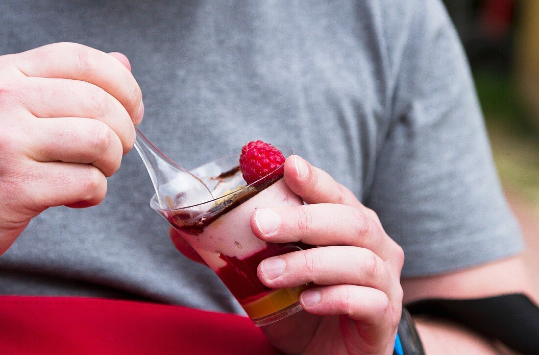 A man eating a raspberry cream dessert