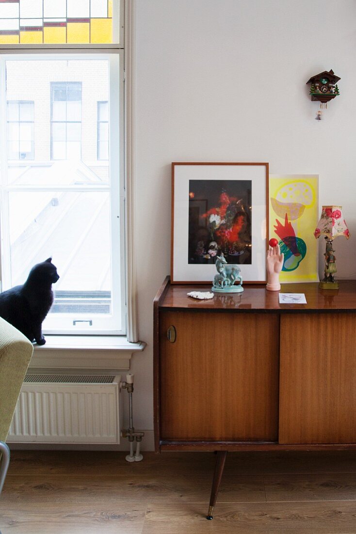 Dekoobjekte auf Sideboard im Fiftiesstil neben Fenster