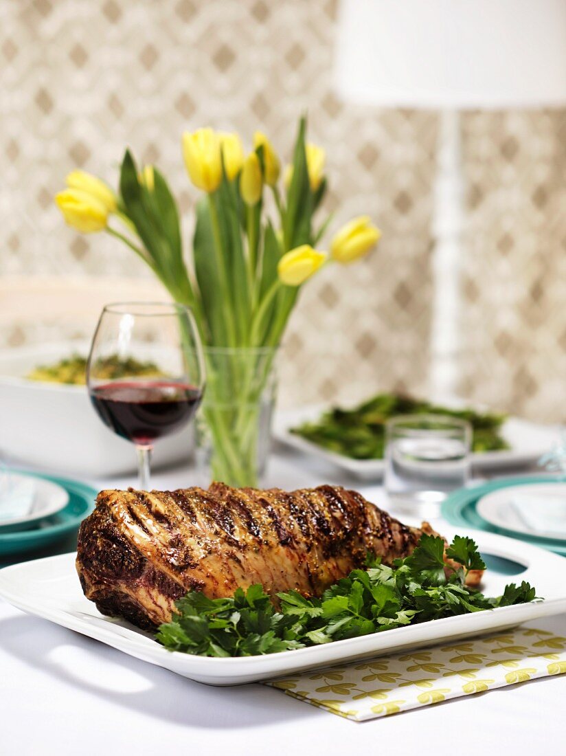 Roast lamb and a glass of red wine on an Easter table