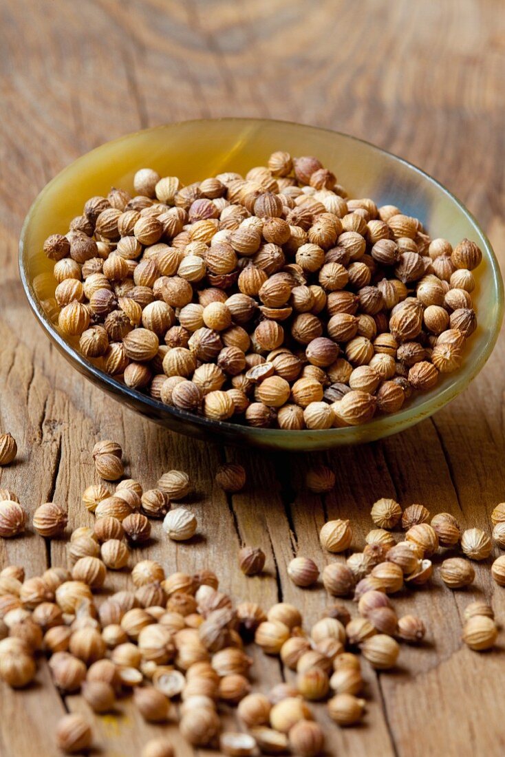 Coriander seeds in a bowl and next to it