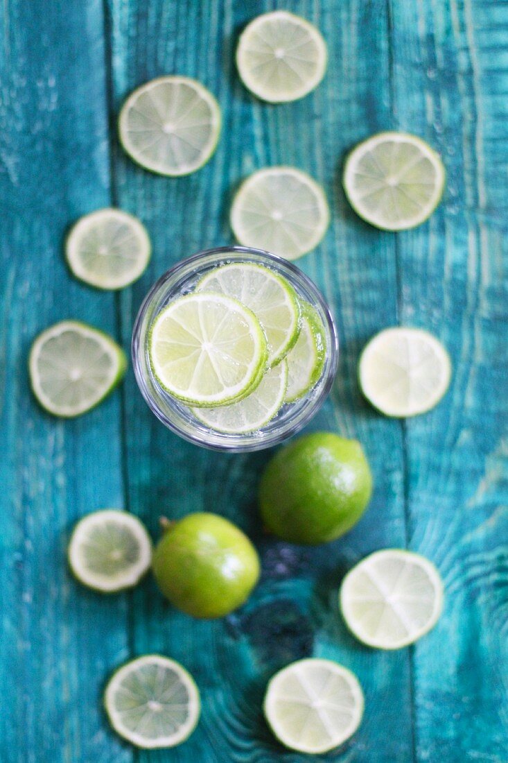 A glass of water with lots of limes