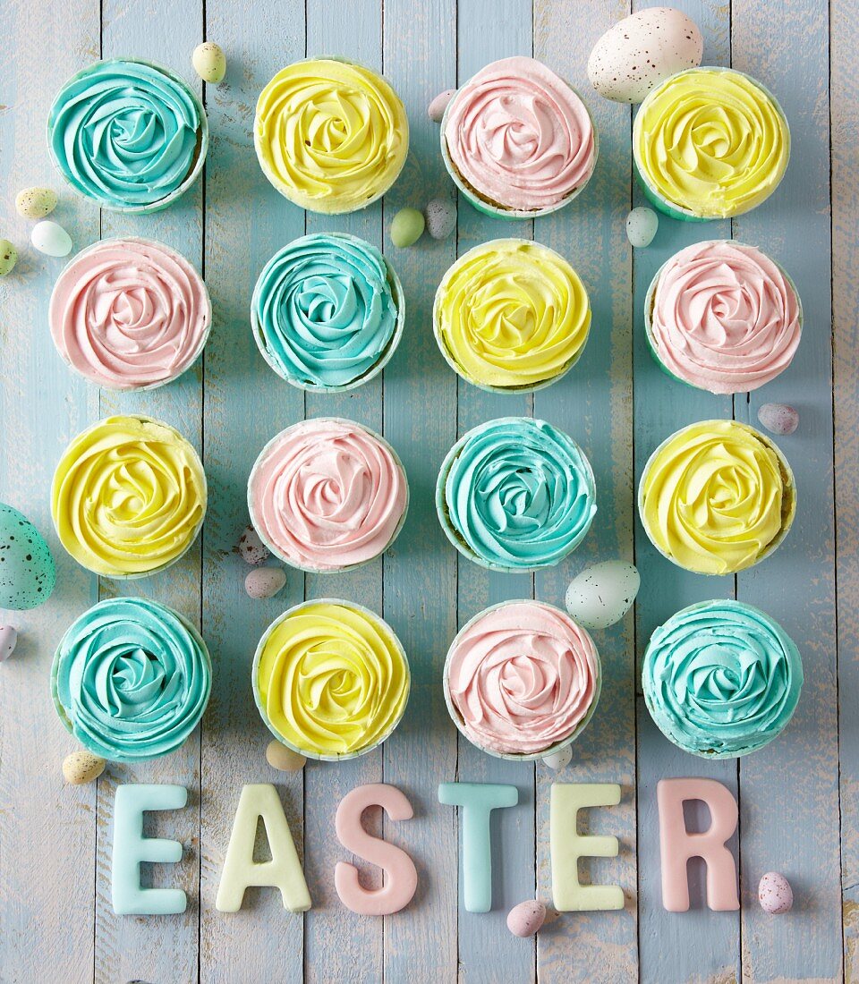 Cupcakes mit pastellfarbigen Cremehauben fürs Osterfest