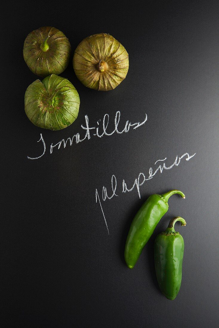 Tomatillos und Jalapenos auf Schiefertafel mit Schrift
