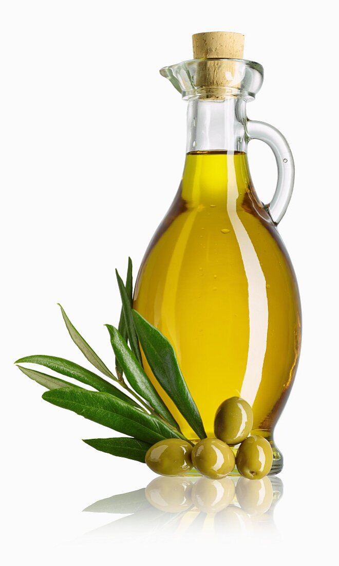 Olivenölkaraffe, Olivenzweig und grüne Oliven